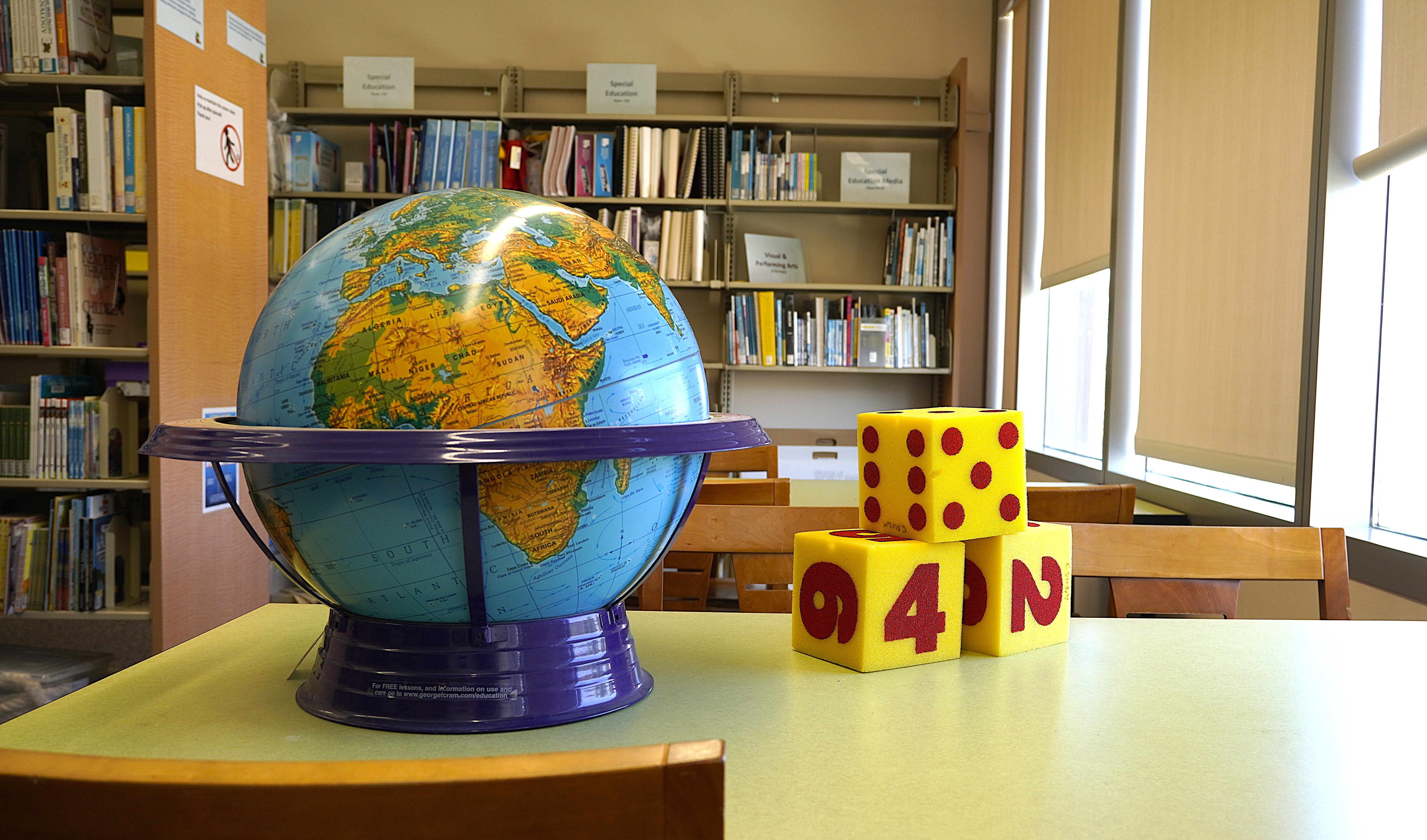 A photo of a globe and 3 foam dice
