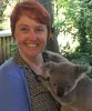Woman smiling while holding a koala